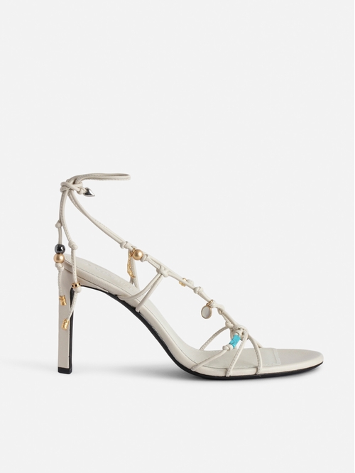 Smooth leather heeled sandals with tied straps and charms. -